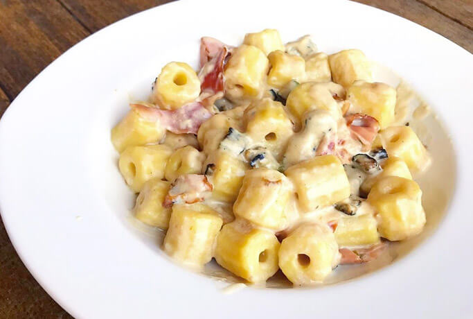 Potato macaroni with cream, bacon and zucchini